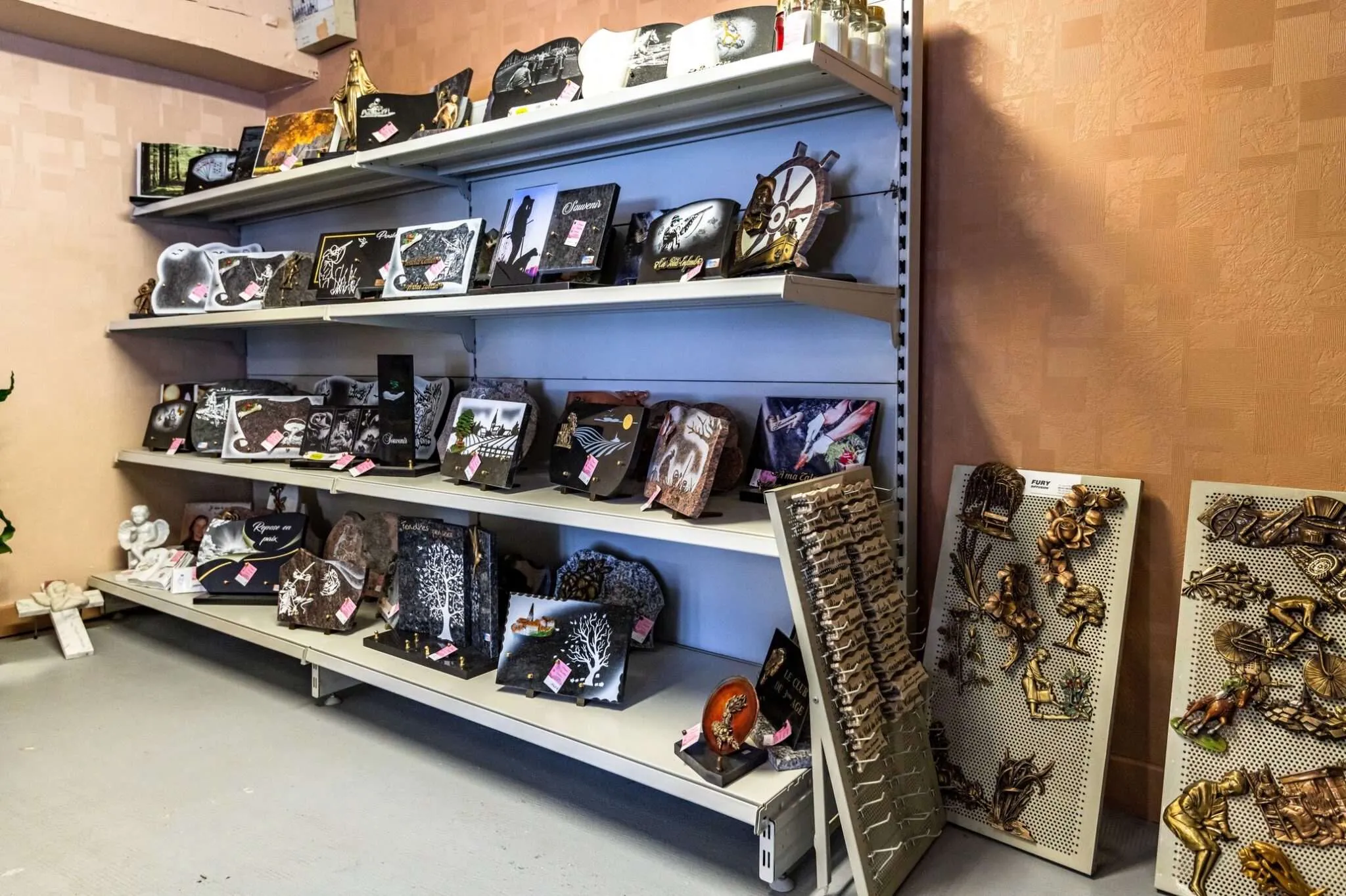 Exposition en magasin de plaques mortuaires et ornements en bronze